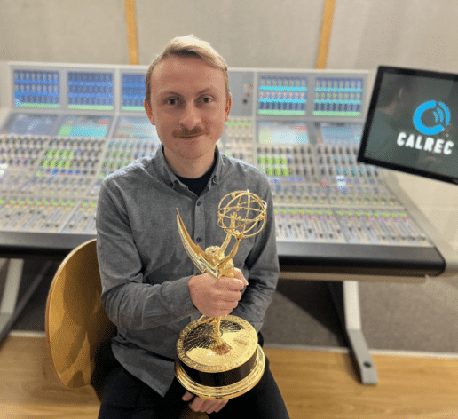 Customer Support Engineer, Elliot Roberts with his Emmy Award in front of Calrec Apollo at Calrec's headquarters